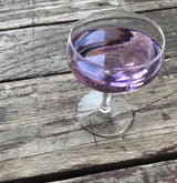 Purple cocktail in a glass on a wooden surface