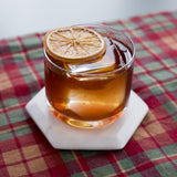 Glass of iced tea with a dried orange slice on a checkered tablecloth