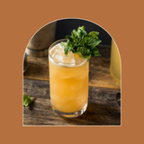 Orange cocktail with mint garnish on a wooden surface