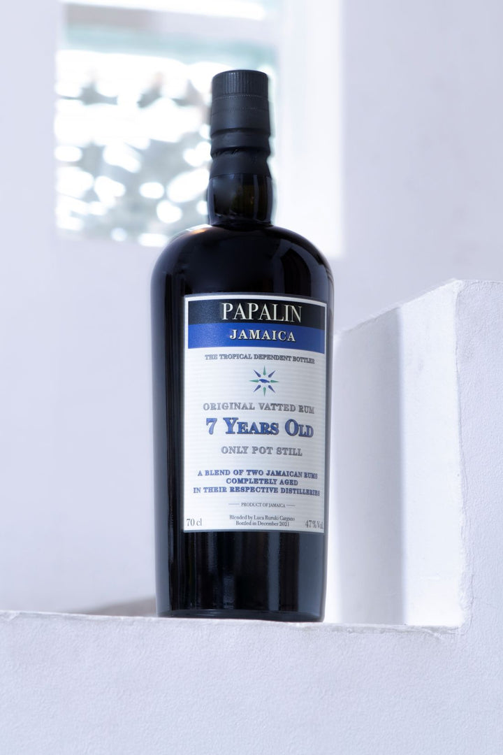 Bottle of Papalin Jamaica rum with a white label on a light background