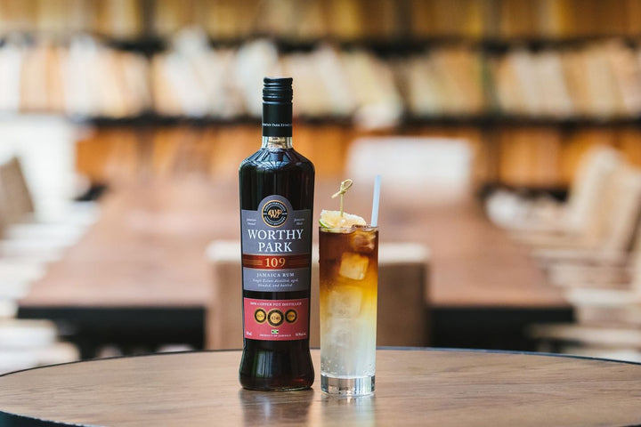 Bottle of Worthy Park rum on a table with a blurred bar background