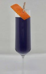Purple cocktail in a flute with an orange twist on a white background