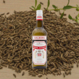 Bottle of Aalborg Taffel Akvavit, over background of  caraway and fennel seeds.