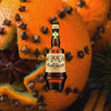 Bottle of Amaro Montenegro Italian Liqueur over backdrop of a fruit.