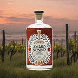 Bottle of Amaro Nonino over a faded backdrop of a vineyard