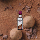 Bottle of Angostura Cocoa Bitters over a blurred background of cocoa grounds and chocolate shavings.