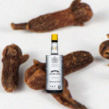 Bottle of Angostura bitters over a background of dark bananas.