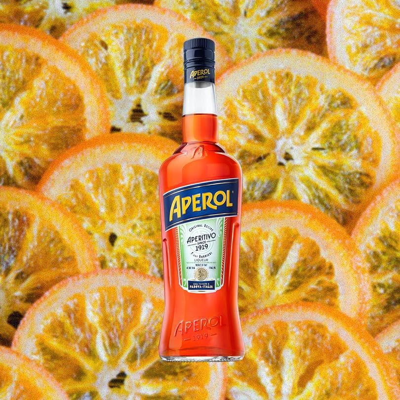 Bottle of Aperol Aperitivo over a backdrop of orange slices.