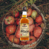 Bottle of Laird's Straight Applejack 86 over background image of apples in a basket.