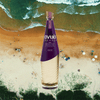Bottle of Avua Oak Cachaca over background of beach