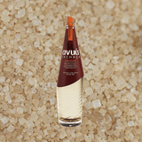 Bottle of Avua Amburana Cachaca over grain, salt, or sand material