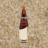 Bottle of Avua Amburana Cachaca over grain, salt, or sand material