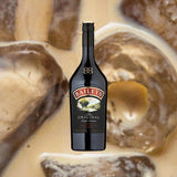 Bottle of Bailey's Irish Cream. Backdrop coffee drink with ice cubes.