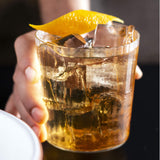 Cocktail in a glass being held out.