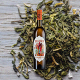 Bottle of Baldoria Bitter Vermouth over background image of dried green plant on the ground.