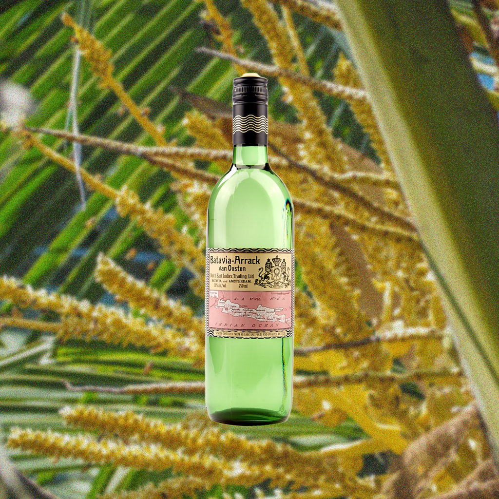 Bottle of Batavia Arrack van Oosten over a blurred background of plants.