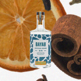 Bottle of Bayab Classic Dry Gin over backdrop image of spices and oranges.