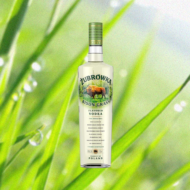 750ml bottle of Zubrowka Bison Grass Vodka over backdrop of green grass.