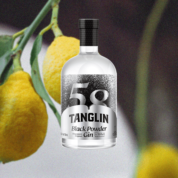 Bottle of Tanglin Black Powder Gin over backdrop image of lemon plant.