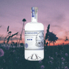 Bottle of St. George Botanivore Gin. Backdrop of flower field at sunset.