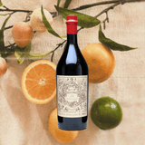 Bottle of Carpano Antica Formula Vermouth oranges, lime and flower in the background