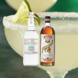 Bottles of Casamigos Blanco Tequila and Pierre Ferrand Dry Curacao. over close up of a margarita in a glass with limes and salted rim.