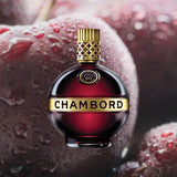 Bottle of Chambord Liqueur. Backdrop of frozen purple fruit.