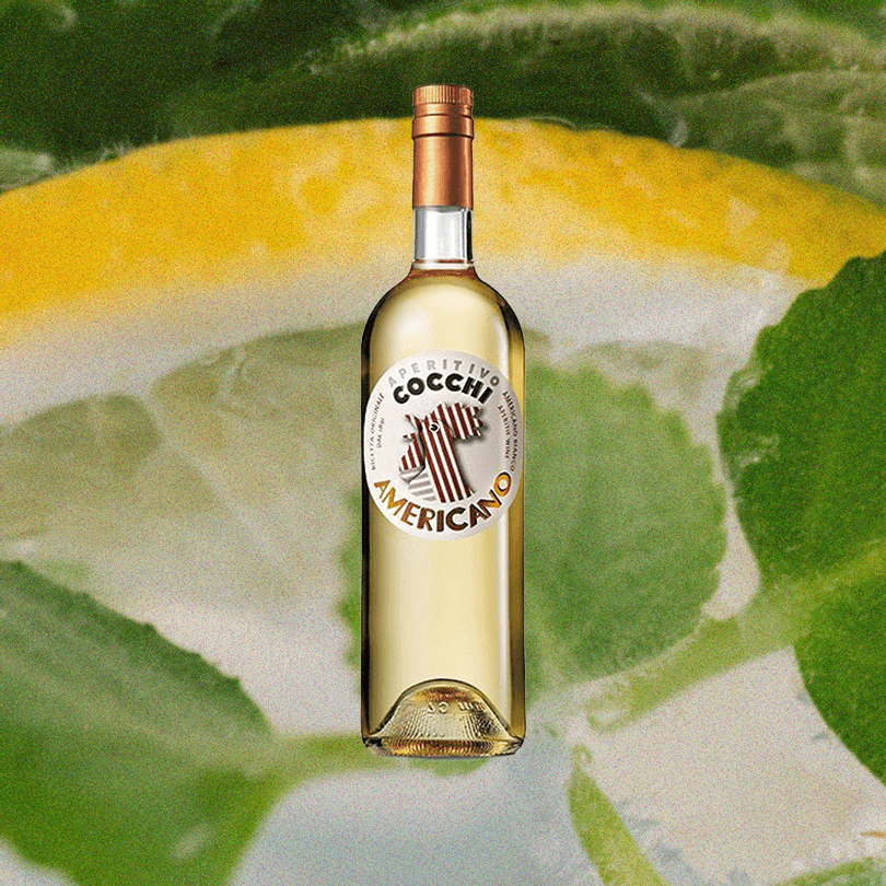 Cocchi American Bianco bottle over a background of a lemon slice upclose.