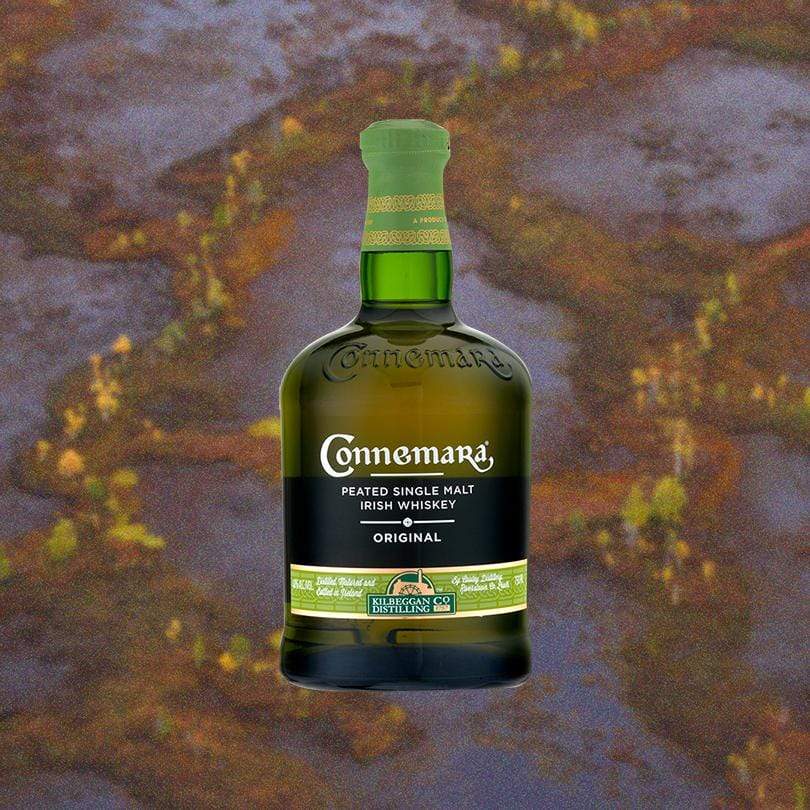 Connemara Original Peated Single Malt Whiskey 12 Year over blurry brown backdrop.
