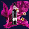 Bottle of Giffard Crème de Violette Liqueur. Backdrop of vibrant violet flower.