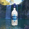 Bottle of Deep Eddy Original Vodka over backdrop of a waterfall.