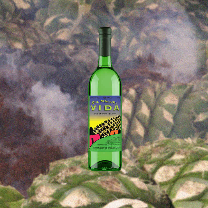 Bottle of Del Maguey VIDA over a smoky backdrop of agave plants.