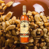 Bottle of Denizen Merchant's Reserve 8 Year Rum over backdrop of caramel apple.