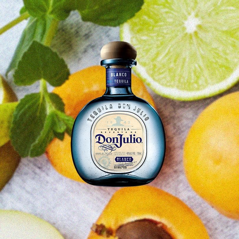 Bottle of Don Julio Blanco Tequila over beautiful backdrop of citrus fruits.