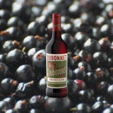 Bottle of Dubonnet Rouge over backdrop of blueberries. 
