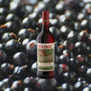 Bottle of Dubonnet Rouge over backdrop of blueberries. 