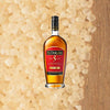 Bottle of El Dorado 5 Year Aged Rum. Backdrop of light colored sugar.