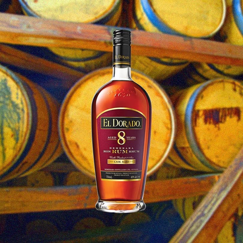 Bottle of El Dorado 8 Year over backdrop of barrels