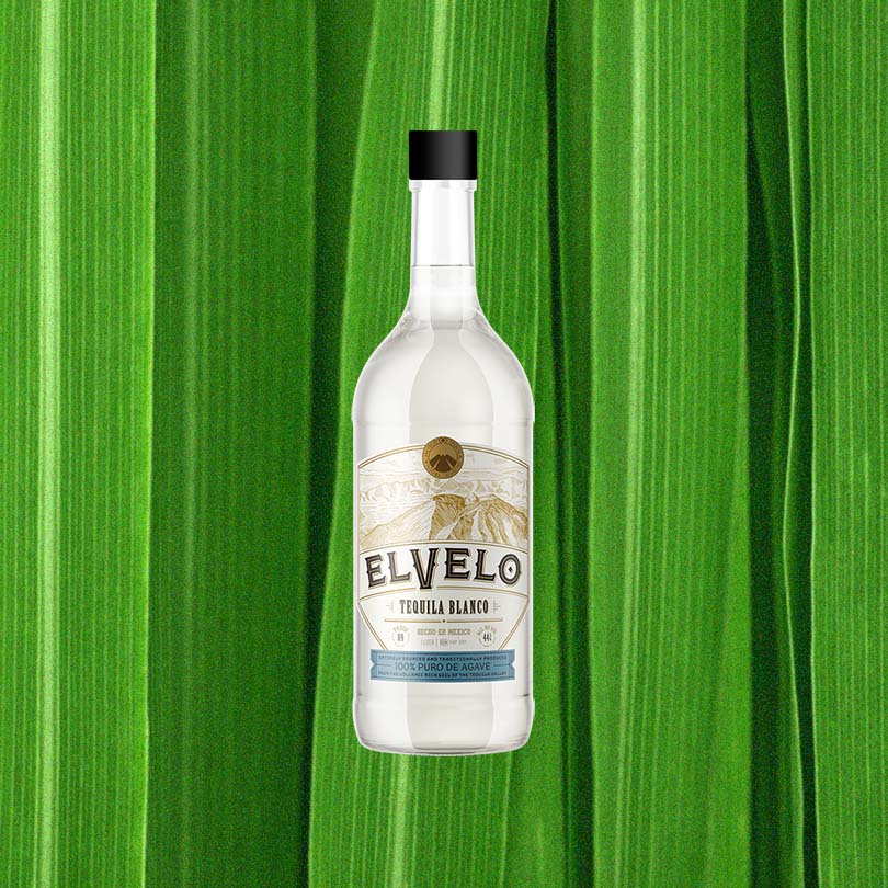 Bottle of ElVelo Tequila Blanco over backdrop of lime green paneling.