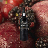 Bottle of Fonseca Bin #27 Port Wine over backdrop of berries and plums close up.