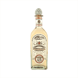 Bottle of Fortaleza Tequila Reposado the label is vintage with red details. The top of the bottle has the signature agave cork topper.