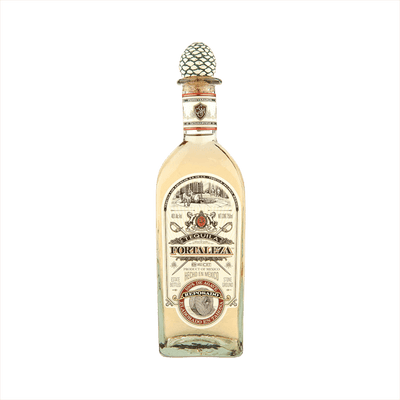 Bottle of Fortaleza Tequila Reposado the label is vintage with red details. The top of the bottle has the signature agave cork topper.