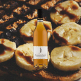 Bottle Giffard Banane du Brésil Liqueur backdrop of faded toast with bananas on it.