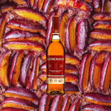 Bottle of Glenmorangie Lasanta 12 Year Scotch, over a blurred background of baked fruit.