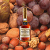 Bottle of Hennessy V.S. Cognac, over a closeup background of grapes, along with various nuts.