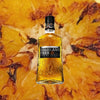 Bottle of Highland Park 12 Year Old Single Malt Scotch over blurry yellow backdrop.
