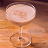 A Pink Squrrel cocktail in a glass on a table.
