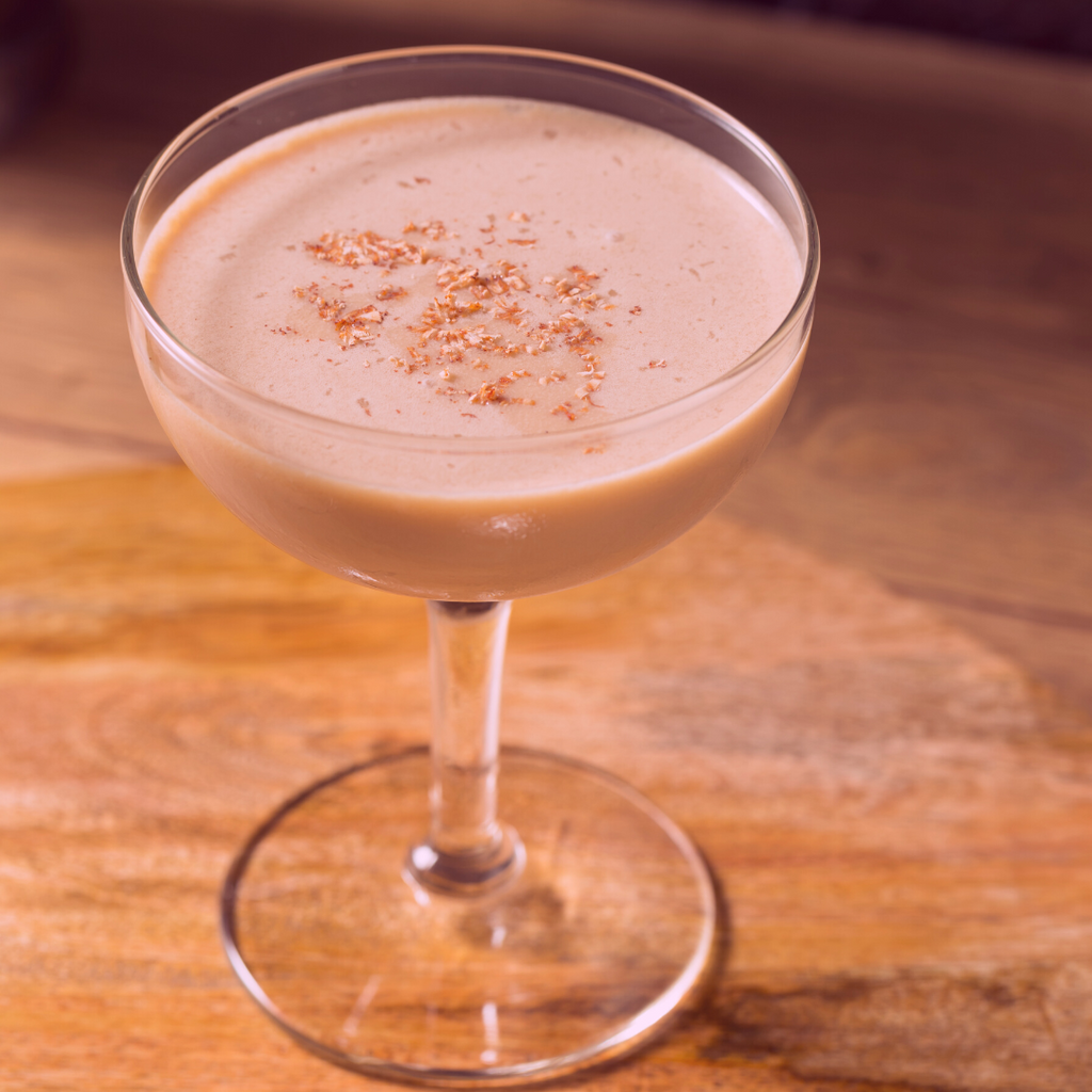 A Pink Squrrel cocktail in a glass on a table.