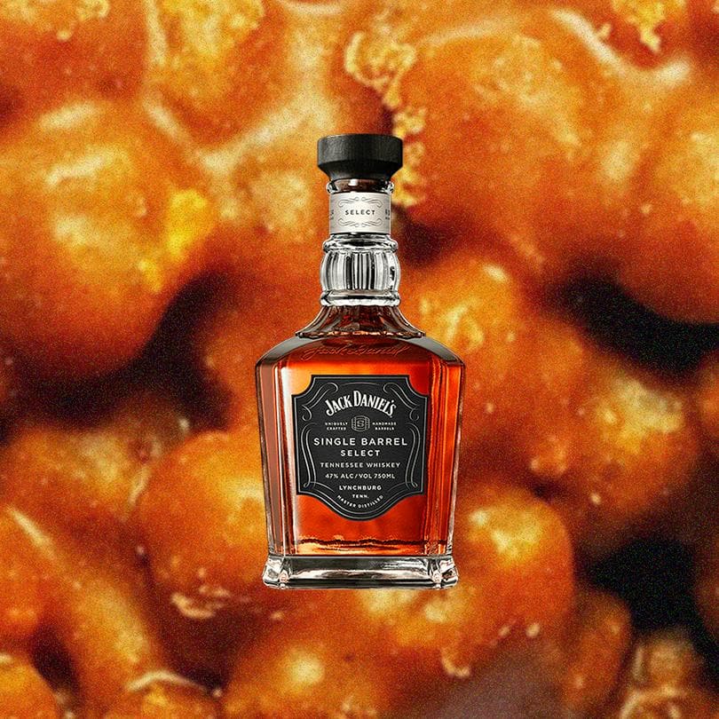 Bottle of Jack Daniel's Single Barrel Bourbon Whiskey over backdrop of indistinguishable yellow, orange, red mush.