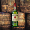 Bottle of Jameson Irish Whiskey. Backdrop of whiskey barrels.